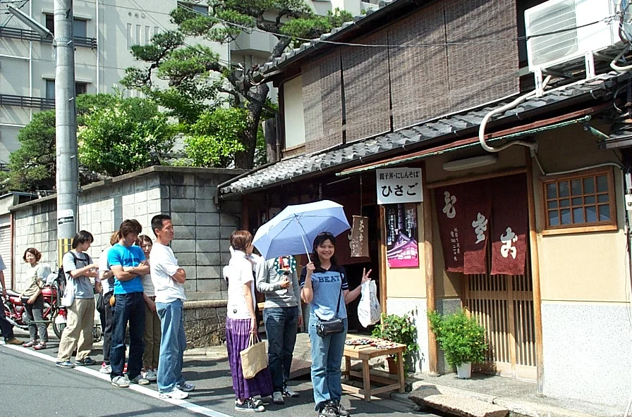 午餐店外排隊時,太太撐傘對鏡頭比 YA
