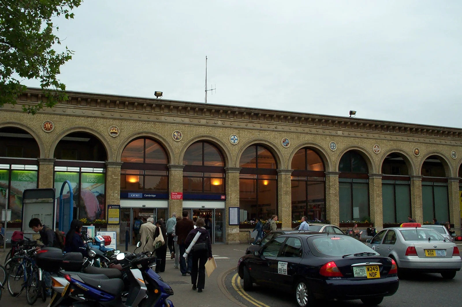 Cambridge 火車站外的行人、車輛、自行車與拱形站體