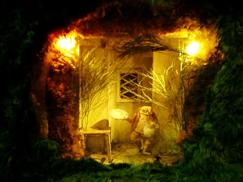 小動物角色站在模型屋門口的室內展示。