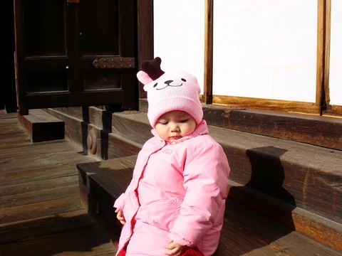 小孩在光明寺冬日陽光下休息。