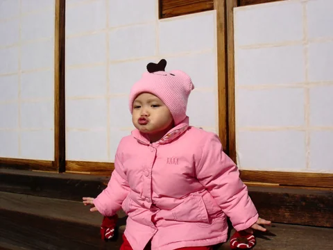 小孩坐在戶外享受冬天陽光。
