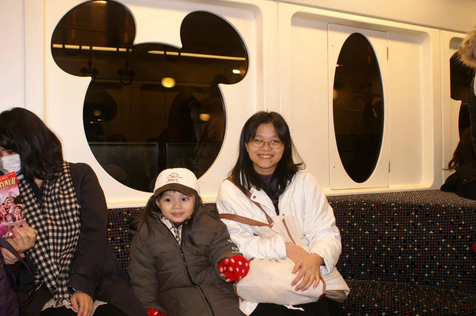 家人在有米奇造型車窗的迪士尼環狀捷運內。