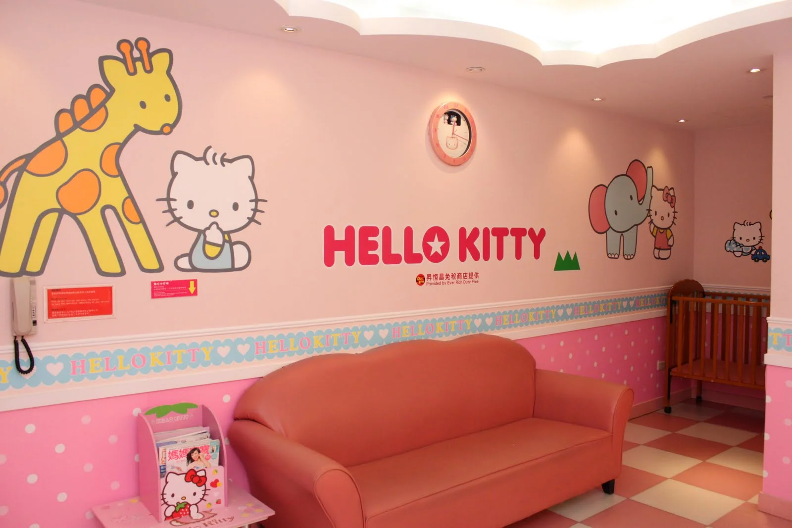 兩個小朋友站在 Hello Kitty 育嬰室外。
