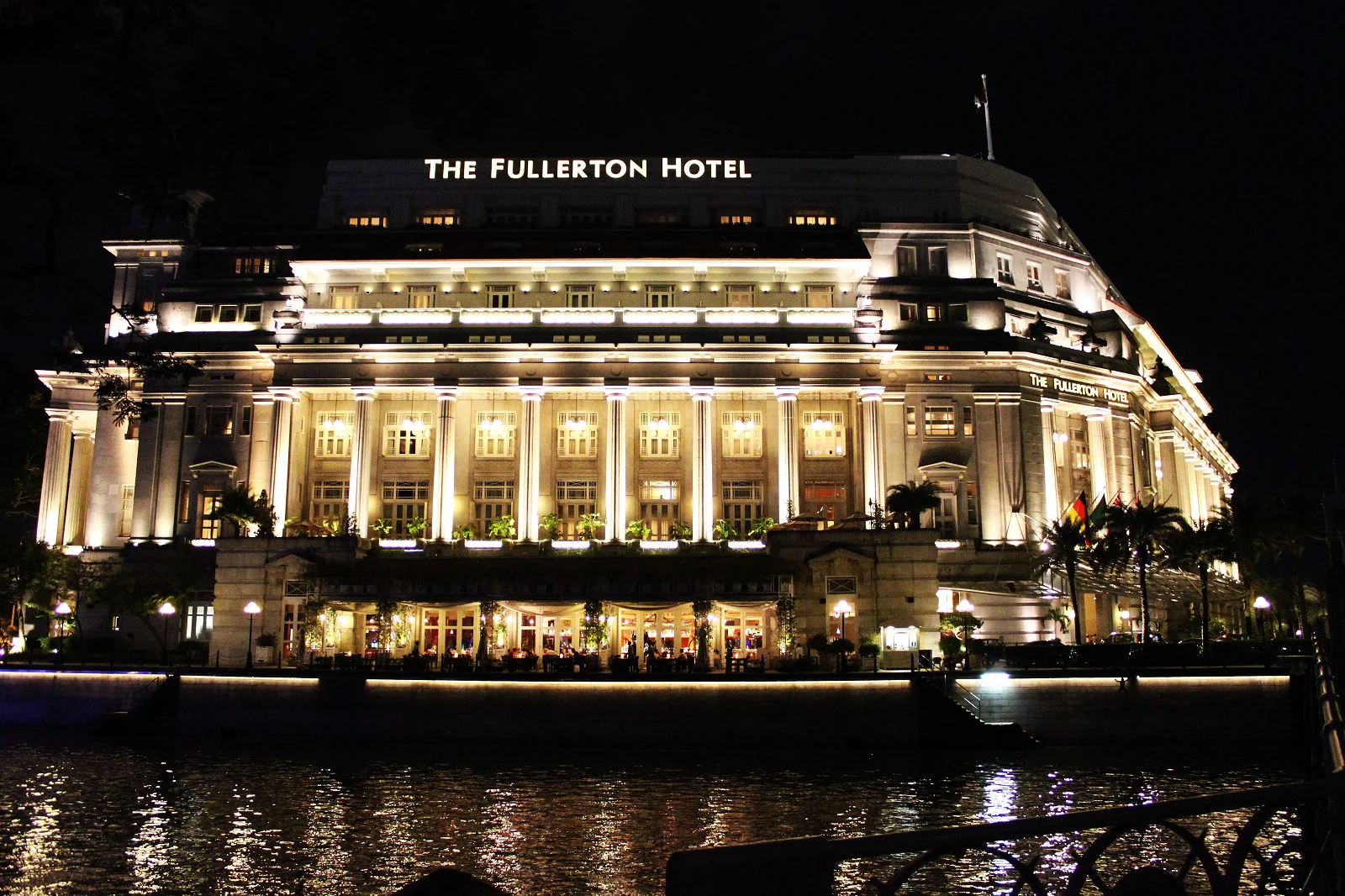 Fullerton Hotel 在夜晚燈光下倒映於河面。