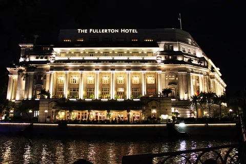 Fullerton Hotel 在夜晚燈光下倒映於河面。