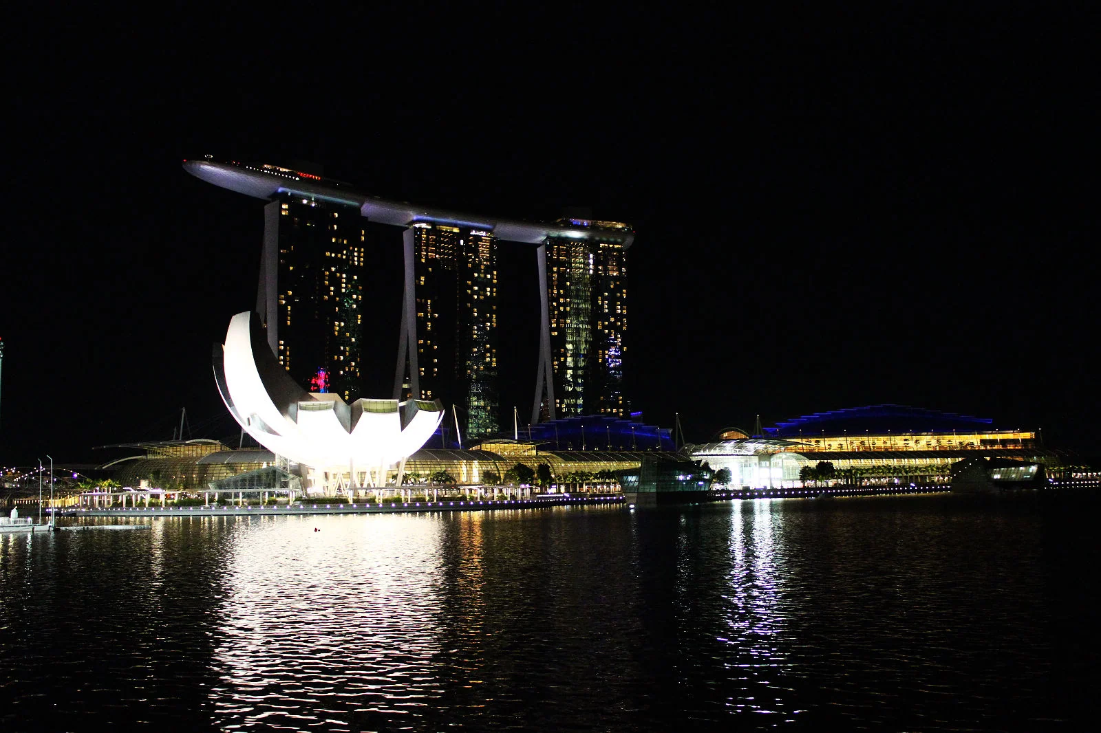 濱海灣金沙旁的白色蓮花造型建築在夜晚亮起燈。
