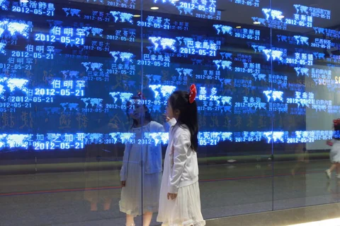 小朋友站在機場藍色數位牆前。