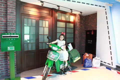 小朋友站在機場綠色主題裝置旁。